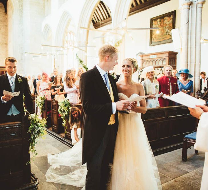 Bride and Groom at the Altar with Bride in Halfpenny London Wedding Dress and Groom in Traditional Morning Suit