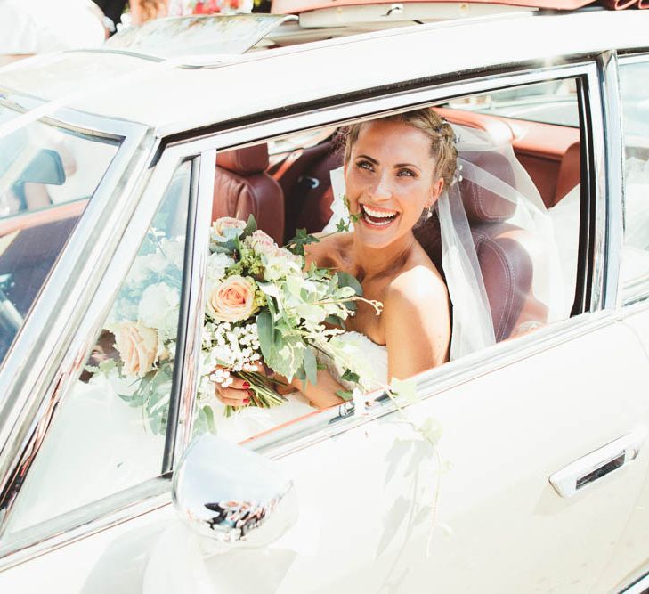 Smiley Bride with Braided Up Do Sitting in the Wedding Car