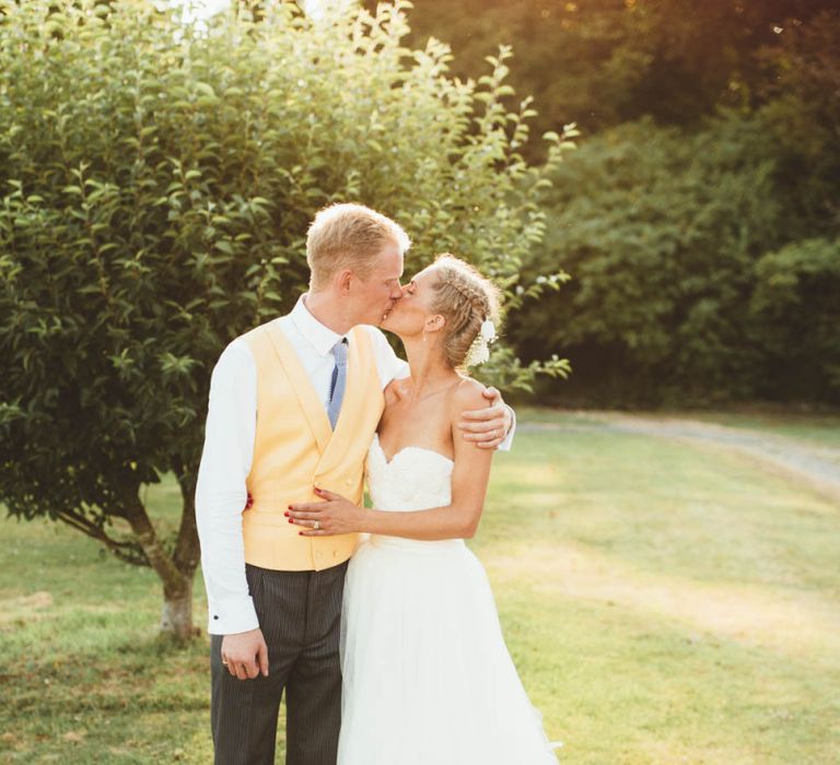 Bride in Tulle and Applique Halfpenny London Wedding Dress with Groom in Yellow Waistcoat and Blue Tie Hugging