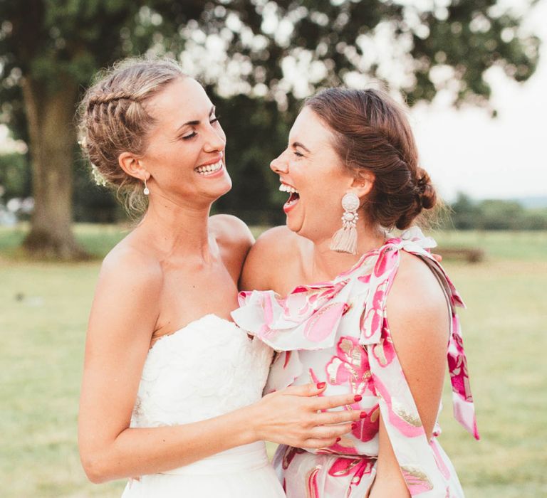 Bride in Tulle and Applique Halfpenny London Wedding Dress with Braided Up Do and Friend in Floral Dress