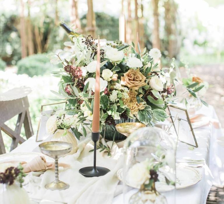 Wedding table decor with floral centrepiece and coloured taper candles