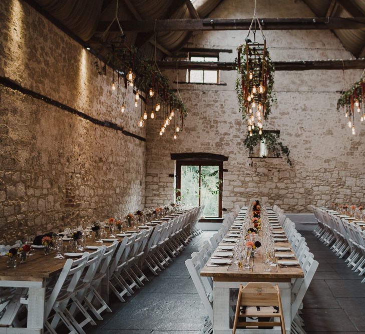 Rustic Reception with, Trestle Tables, Flowers in Bottles and Hanging Edison Bulb Installation