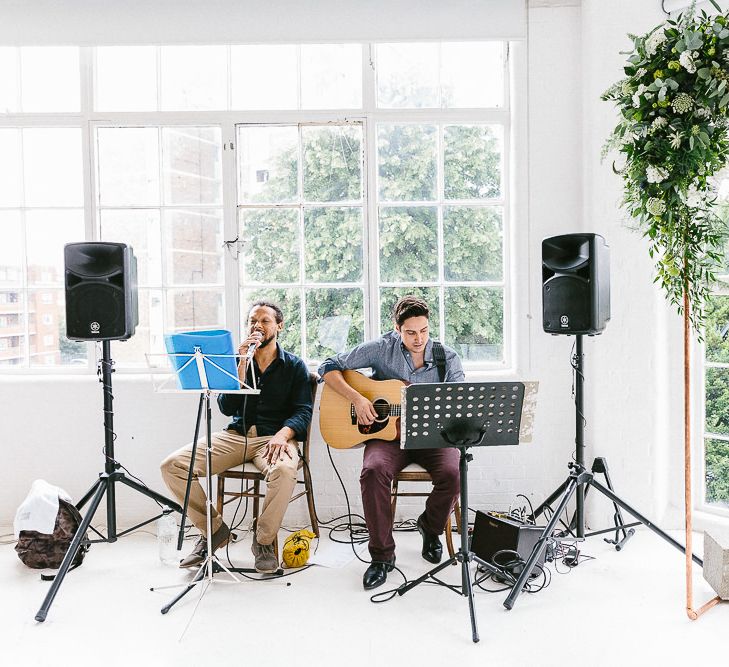 Wedding Ceremony | Acoustic Duo | Copper Arch with White Flowers and Foliage | Whitewashed Walls | Same Sex Wedding with Industrial Styling at Wimborne House | Marmelo Photography