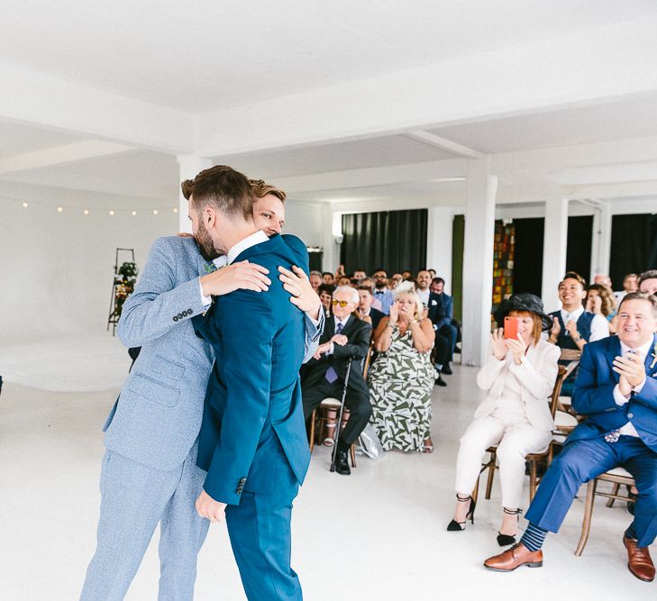 Wedding Ceremony | Just Married | Festoon Lights | Groom in Dark Petrol Blue Suit by Paul Smith | Groom in Light Blue Made-To-Measure Suit by Beggars Run | Same Sex Wedding with Industrial Styling at Wimborne House | Marmelo Photography