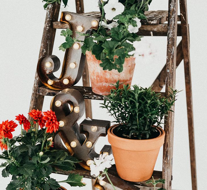 Industrial Ladder with Potted Plants | Copper Letter Lights | Same Sex Wedding with Industrial Styling at Wimborne House | Marmelo Photography