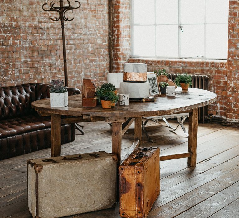 Wedding Reception Decor | Marble Wedding Cake with Copper Leaf | Potted Plants | Vintage Suitcases | Coat Stand | Same Sex Wedding with Industrial Styling at Wimborne House | Marmelo Photography