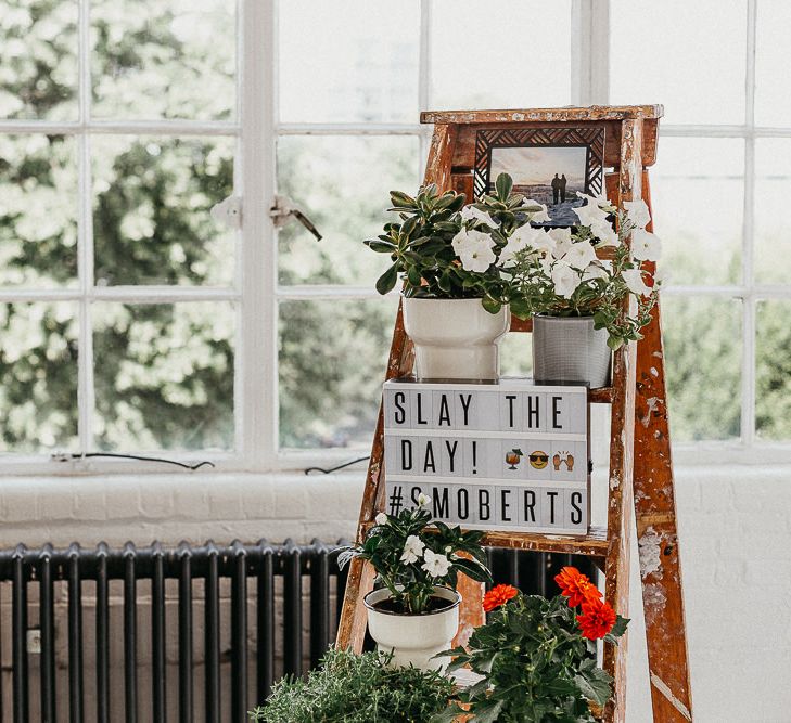 Wedding Reception Decor | Industrial Ladder with Potted Plants | Light Box | Large Warehouse Window | Same Sex Wedding with Industrial Styling at Wimborne House | Marmelo Photography