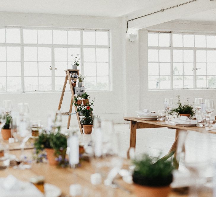 Wedding Reception Decor | Trestle Tables | Huge Warehouse Windows | Whitewashed Walls | Industrial Ladder with Potted Plants | Same Sex Wedding with Industrial Styling at Wimborne House | Marmelo Photography