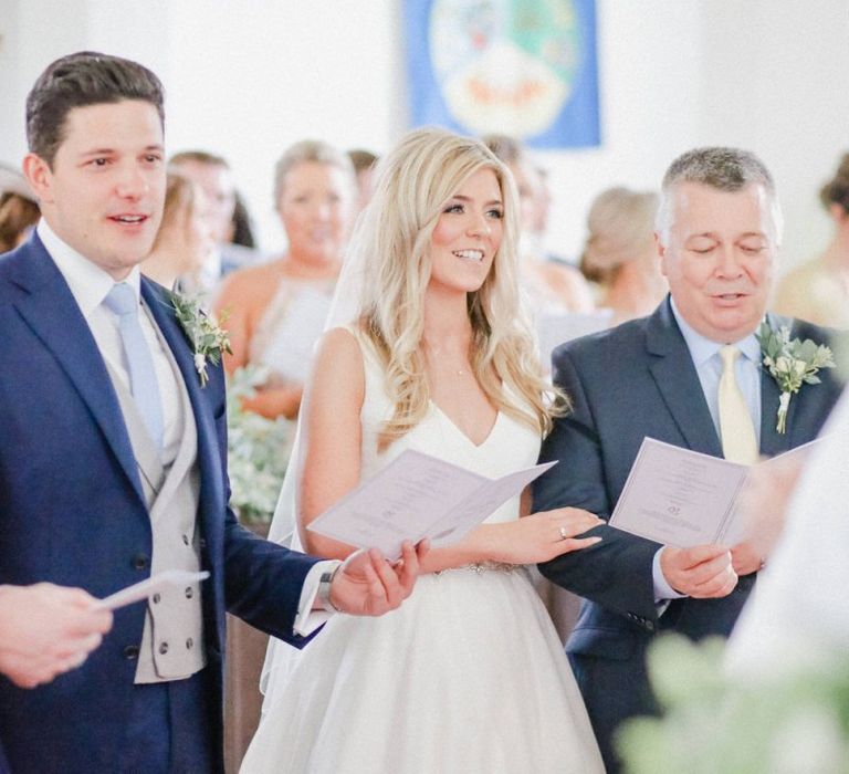 Bride and groom at the church altar singing hymns