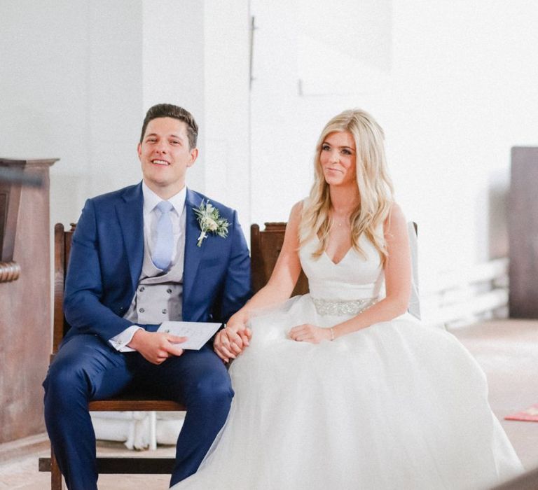 Bride and groom holding hands in the church wedding ceremony