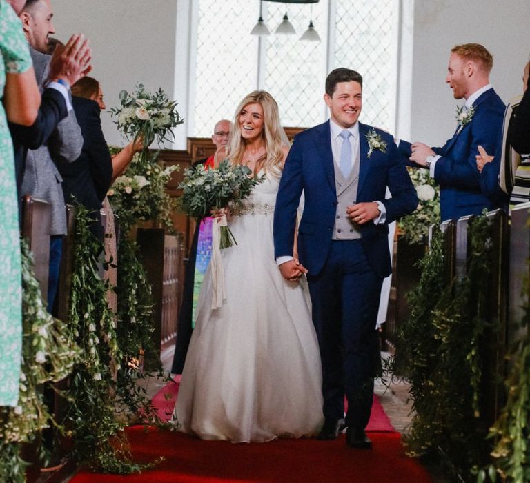 Bride and groom walking up the aisle as husband and wife