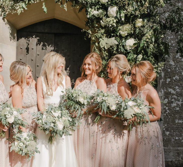 Bridal party portrait outside the church under a floral arch