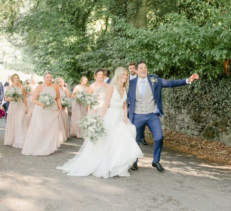 Wedding guests walking from the church to the Askham Hall  reception