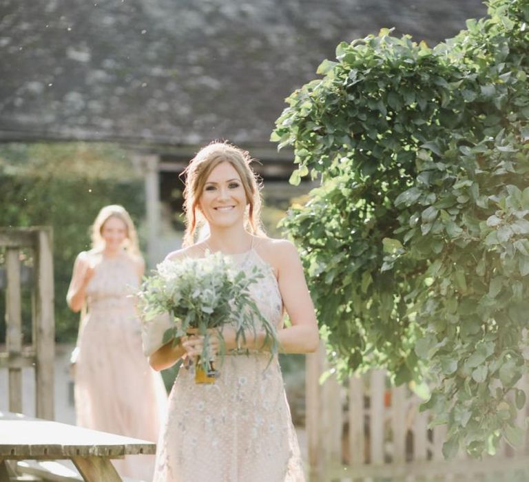 Bridesmaid in pink halter neck dress with embroidery detail