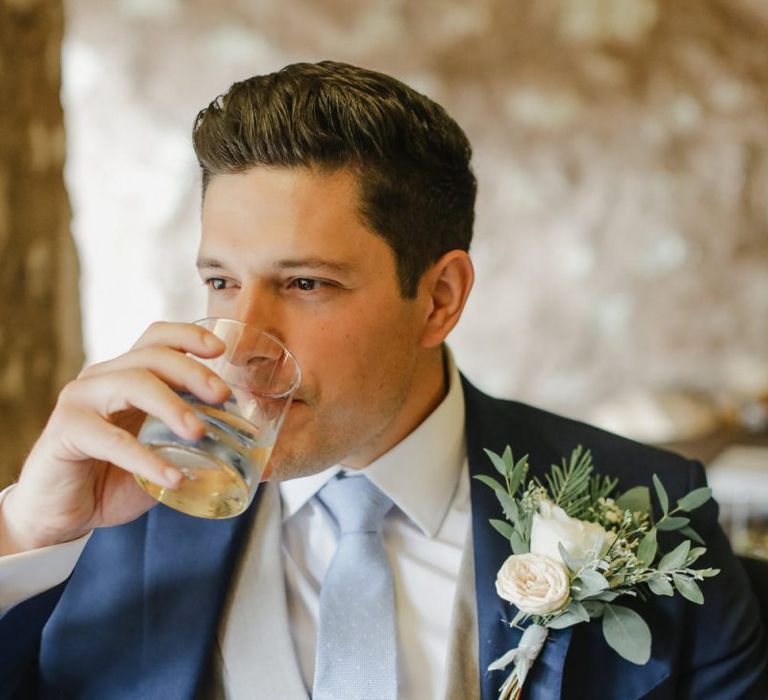 Groom in classic navy suit with grey horseshoe waistcoat