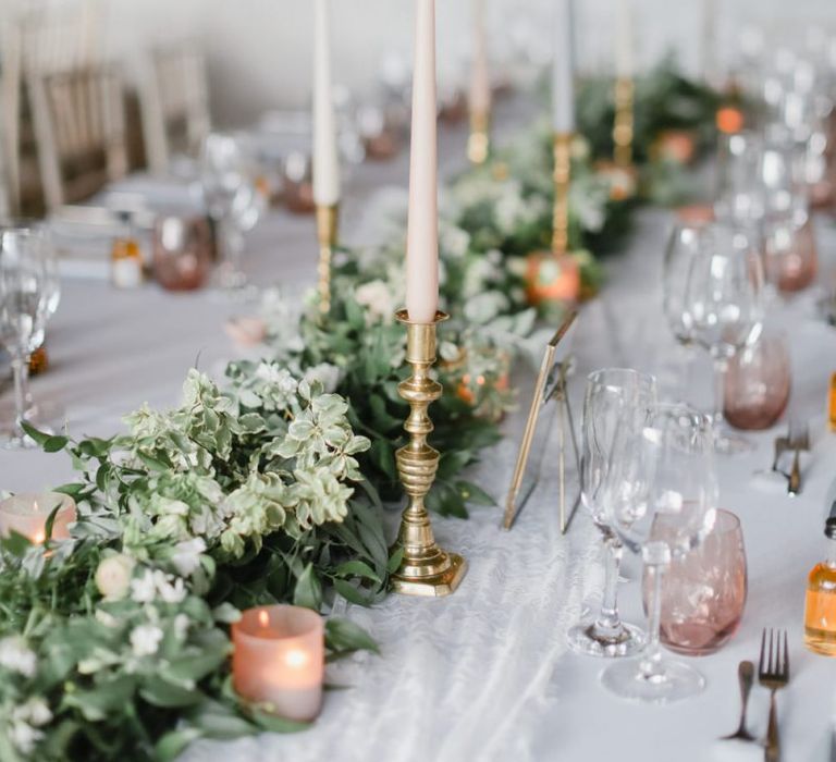 Foliage table runner and coloured taper candles at Askham Hall reception