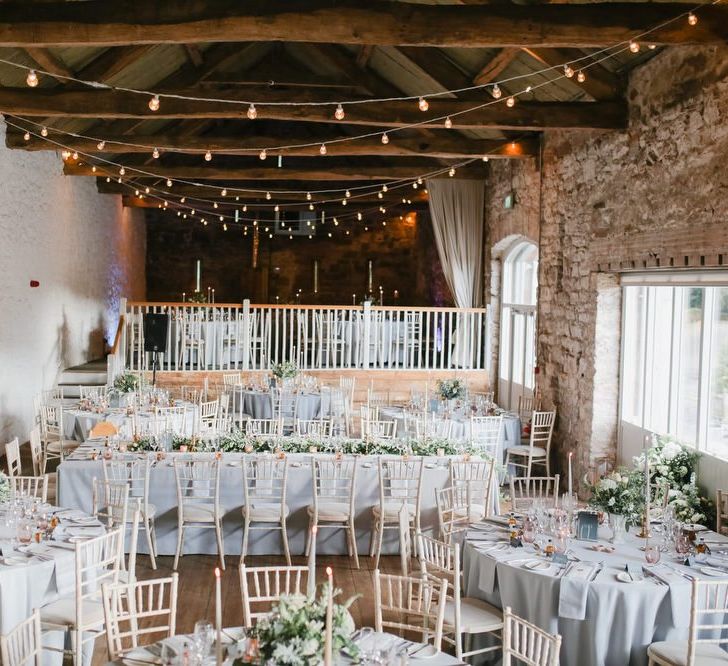 Askham Hall wedding reception with fairy lights, taper candles and foliage