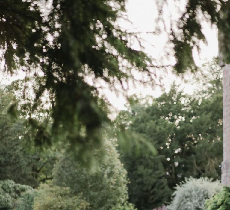 Bride and groom walking through Askham Hall gardens