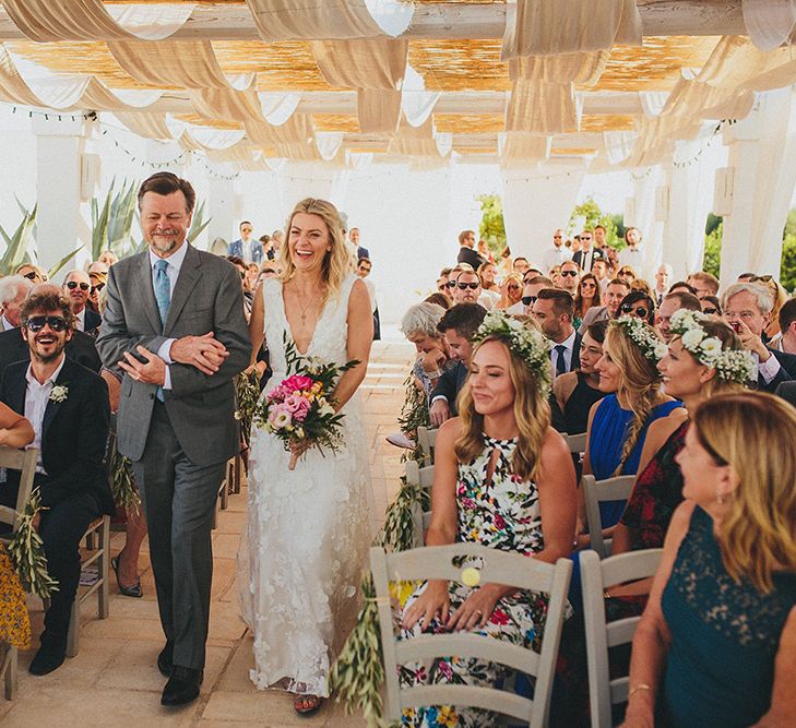 Outdoor Wedding Ceremony | Bridal Entrance in Custom Clemence Halfpenny London Bridal Gown | Brightly Coloured Destination Wedding at Masseria Potenti Wedding Venue, Puglia, South Italy | Petar Jurica Photography | Marco Odorino Film