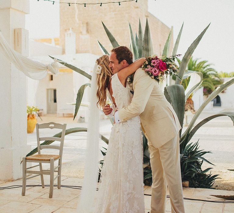 Outdoor Wedding Ceremony | Bride in Custom Clemence Halfpenny London Bridal Gown | Groom in Cream Three Piece Suit | Brightly Coloured Destination Wedding at Masseria Potenti Wedding Venue, Puglia, South Italy | Petar Jurica Photography | Marco Odorino Film