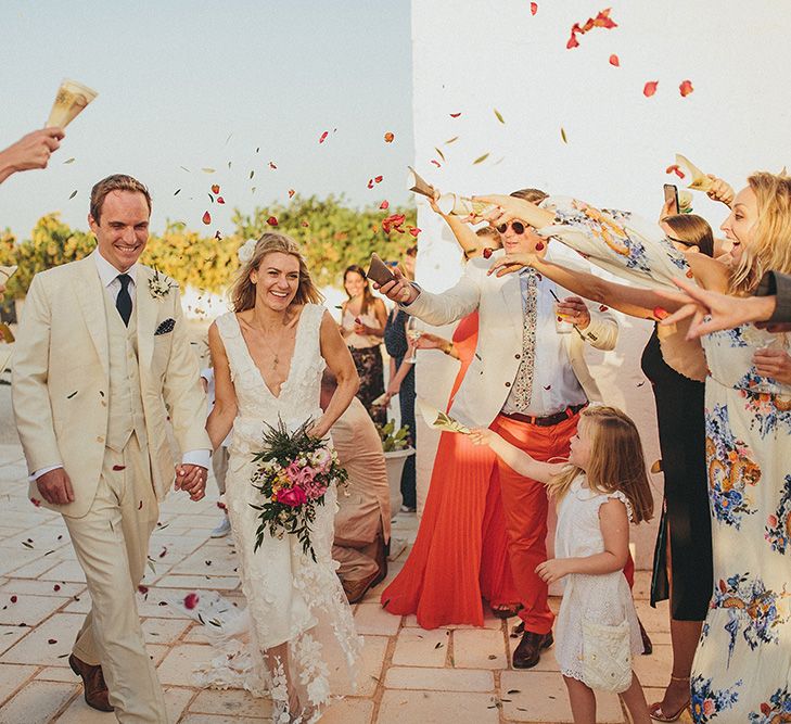 Confetti Moment | Bride in Custom Clemence Halfpenny London Bridal Gown | Groom in Cream Three Piece Suit | Brightly Coloured Destination Wedding at Masseria Potenti Wedding Venue, Puglia, South Italy | Petar Jurica Photography | Marco Odorino Film