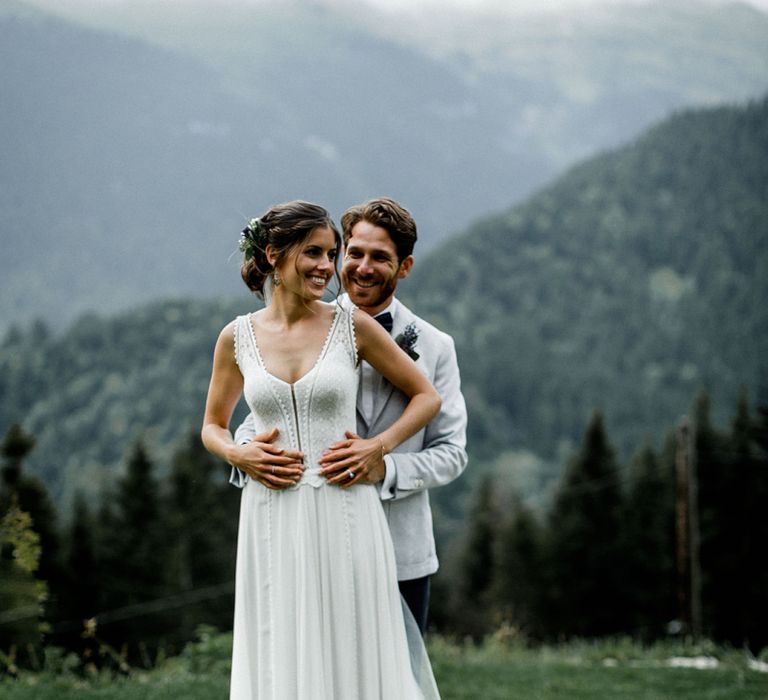 Bride in Mariées Passion Wedding Dress and Groom in Grey Blazer Embracing