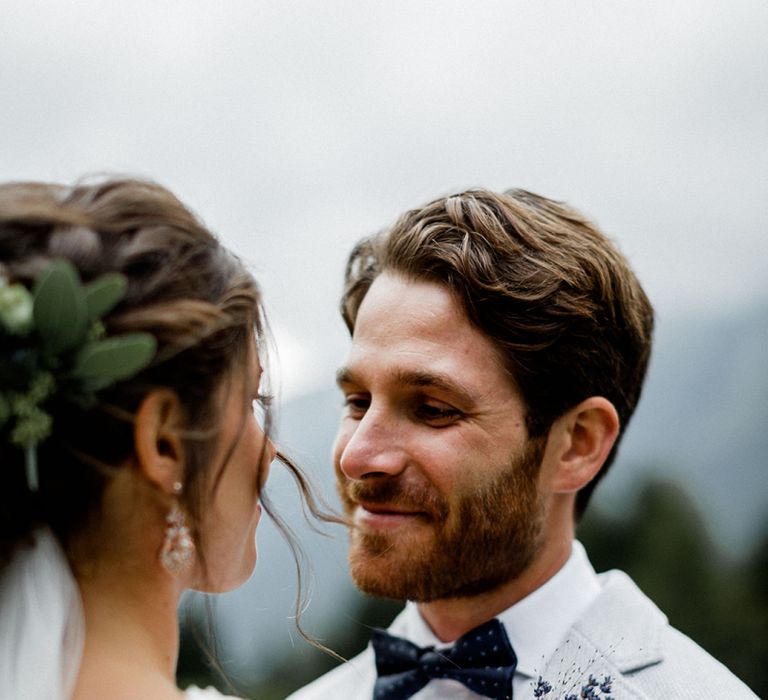 Bride in Mariées Passion Wedding Dress and Groom in Grey Blazer with Blue Buttonhole