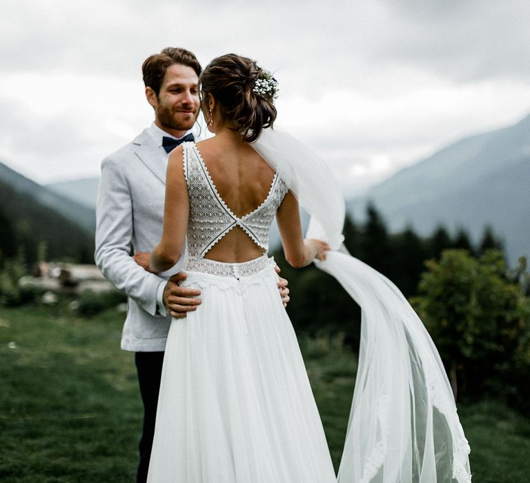 Bride in Backless Mariées Passion Wedding Dress and Groom in Grey Blazer and Navy Chinos