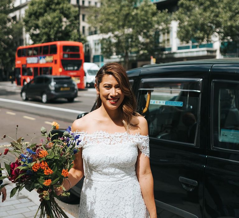 Bride in Lace Whistles Wedding Dress with High/Low Hem and Bardot Neckline | Bridal Bouquet with Bright Wild Flowers | High Street Wedding Dress for an Intimate Crouch End Pub Wedding with Bright Flowers | Miss Gen Photography