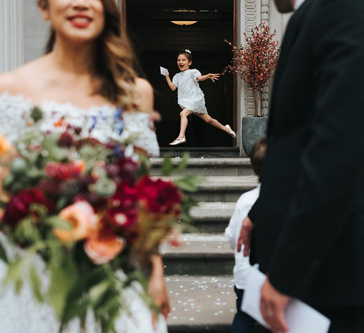 Flower Girl in White Zara Dress with Short Sleeves and Scoop Back | Bride in Lace Whistles Wedding Dress with High/Low Hem and Bardot Neckline | Groom in Black Reiss Jacket and Black Nudie Jeans with Church's Shoes | Bridal Bouquet with Bright Wild Flowers | Wedding Ceremony at Old Marylebone Town Hall | High Street Wedding Dress for an Intimate Crouch End Pub Wedding with Bright Flowers | Miss Gen Photography