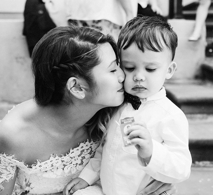 Bride in Lace Whistles Wedding Dress with High/Low Hem and Bardot Neckline | Page Boy in Zara Shirt, Trousers and Bow Tie | High Street Wedding Dress for an Intimate Crouch End Pub Wedding with Bright Flowers | Miss Gen Photography