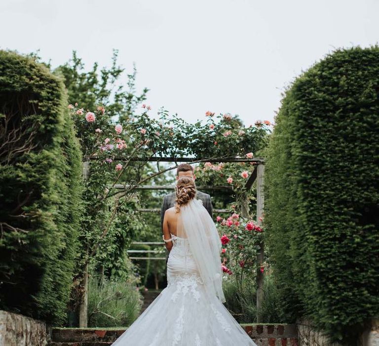 Lace Off The Shoulder Wedding Dress With Veil And Floral Backdrop