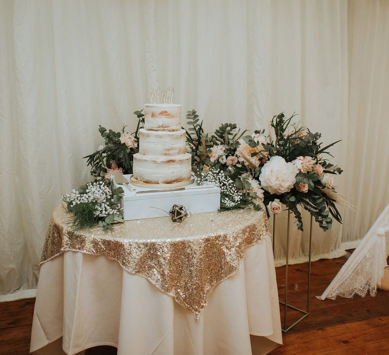 Wedding Cake Table Decorated With Pink and White Floral Backdrop