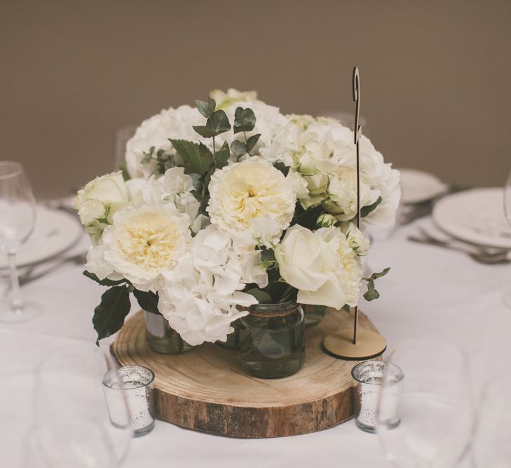 White Flower Centrepiece in Jam Jars on Wooden Tree Slice