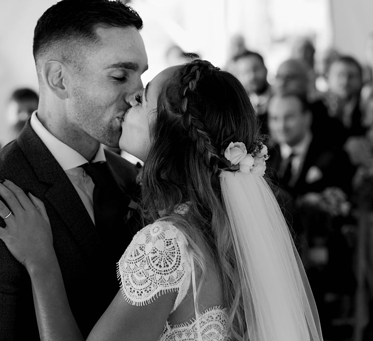 Wedding Ceremony | First Kiss | Bride in Laced KatyaKatya Wedding Dress with Cap Sleeves and Ribbon Belt | Groom in Blue T.M Lewin Suit with Navy Hawkes Bespoke Outfitters Waistcoat | Lace KatyaKatya Dress for Tipi Wedding at Fforest Farm | Claudia Rose Carter Photography