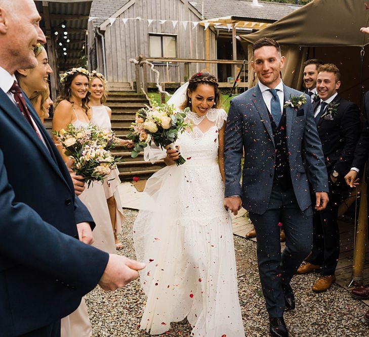 Confetti Throw | Bride in Laced KatyaKatya Wedding Dress with Cap Sleeves and Ribbon Belt | Groom in Blue T.M Lewin Suit with Navy Hawkes Bespoke Outfitters Waistcoat | Bridal Bouquet of Wild Flowers  with Lavender, Thistles, White Roses and Eucalyptus | Lace KatyaKatya Dress for Tipi Wedding at Fforest Farm | Claudia Rose Carter Photography