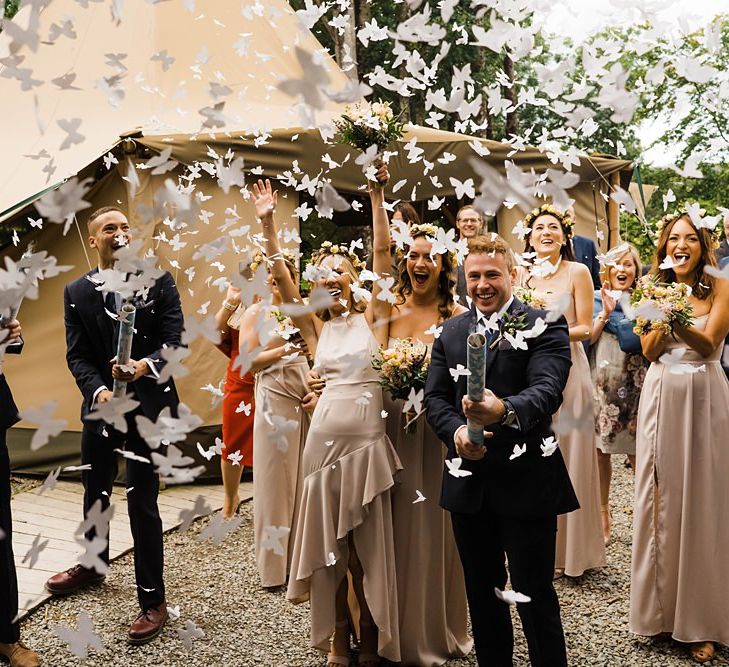 Confetti Cannon | Bridesmaids in Dusty Pink ASOS Dresses | Flower Crowns | Groomsmen in Navy Moss Bros. Suits | Lace KatyaKatya Dress for Tipi Wedding at Fforest Farm | Claudia Rose Carter Photography