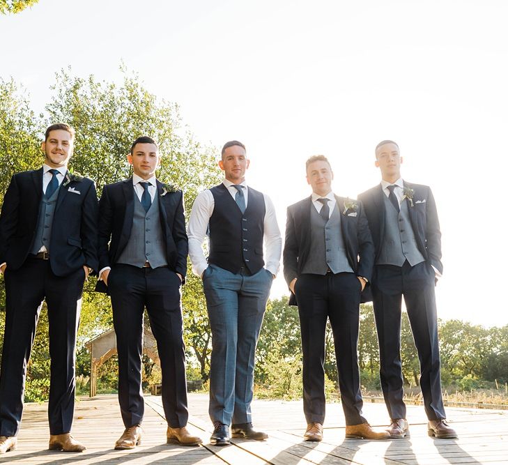 Groom in Blue T.M Lewin Suit with Navy Hawkes Bespoke Outfitters Waistcoat | Groomsmen in Navy Moss Bros. Suits | Lace KatyaKatya Dress for Tipi Wedding at Fforest Farm | Claudia Rose Carter Photography