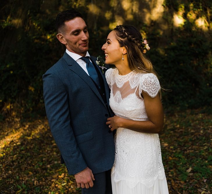 Bride in Laced KatyaKatya Wedding Dress with Cap Sleeves and Ribbon Belt | Groom in Blue T.M Lewin Suit with Navy Hawkes Bespoke Outfitters Waistcoat | Lace KatyaKatya Dress for Tipi Wedding at Fforest Farm | Claudia Rose Carter Photography