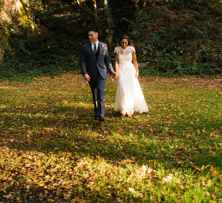 Bride in Laced KatyaKatya Wedding Dress with Cap Sleeves and Ribbon Belt | Red Christian Louboutin Shoes | Groom in Blue T.M Lewin Suit with Navy Hawkes Bespoke Outfitters Waistcoat | Lace KatyaKatya Dress for Tipi Wedding at Fforest Farm | Claudia Rose Carter Photography