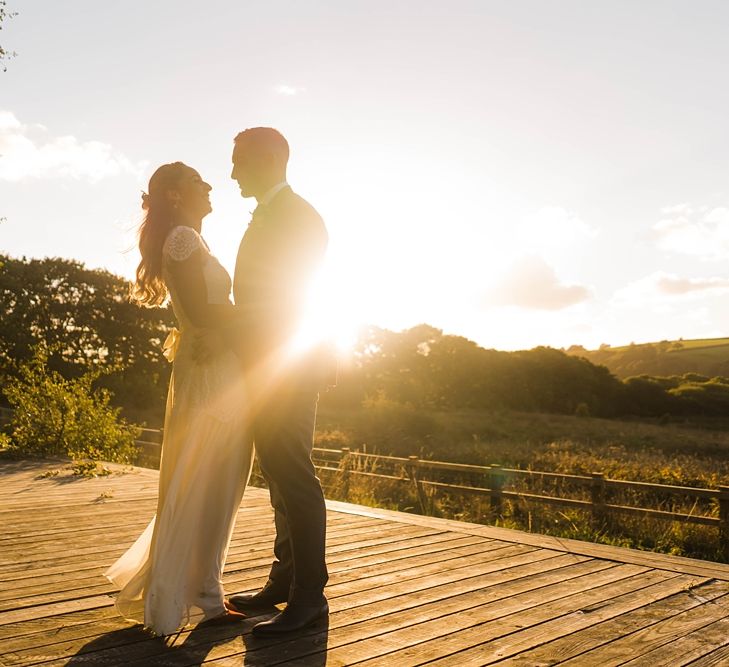 Bride in Laced KatyaKatya Wedding Dress with Cap Sleeves and Ribbon Belt | Red Christian Louboutin Shoes | Groom in Blue T.M Lewin Suit with Navy Hawkes Bespoke Outfitters Waistcoat | Lace KatyaKatya Dress for Tipi Wedding at Fforest Farm | Claudia Rose Carter Photography