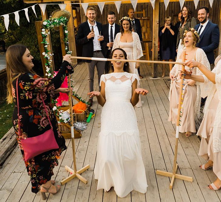 Wedding Reception Entertainment | Limbo | Bride in Laced KatyaKatya Wedding Dress with Cap Sleeves and Ribbon Belt | Bridesmaids in Dusty Pink ASOS Dresses  and White ASOS Kaftans | Flower Crowns | Lace KatyaKatya Dress for Tipi Wedding at Fforest Farm | Claudia Rose Carter Photography