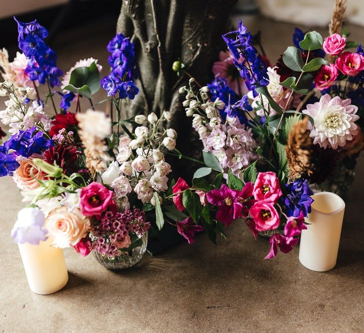 Vibrant floral and candle decor at industrial dry hire wedding venue