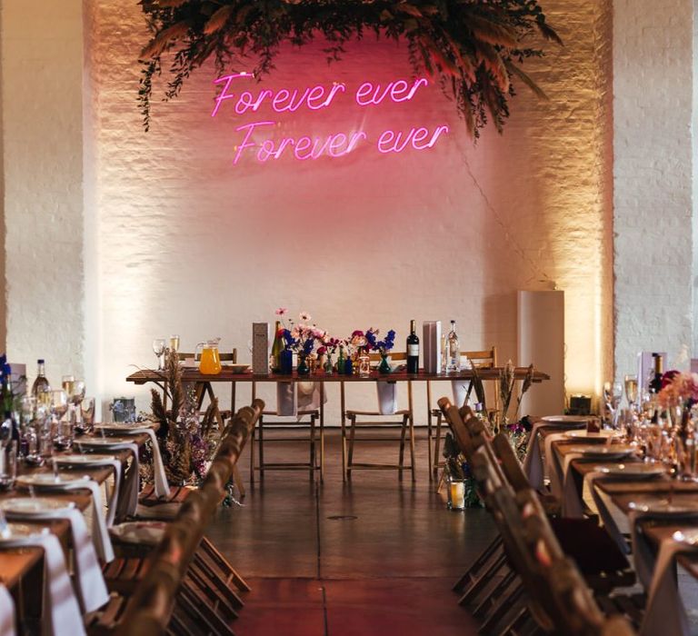 Pink personalised neon sign and foliage decor at dry hire wedding venue