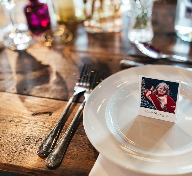 Polaroid style place name settings with colourful glass vase table centrepieces