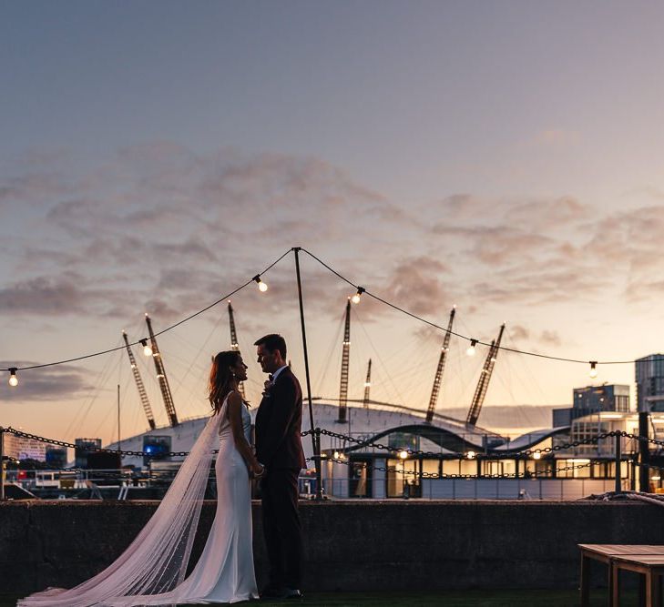 Sunset views across London with bride wearing beautiful Watteau train