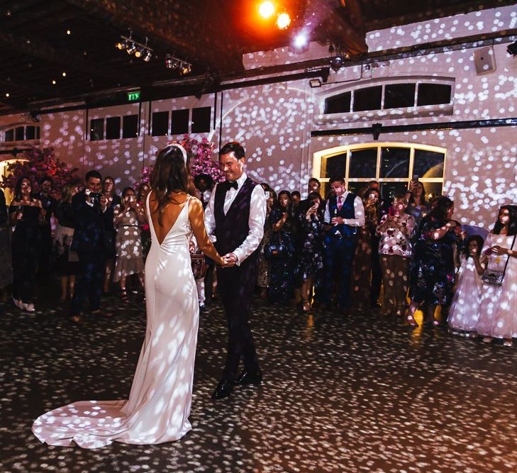 Bride and grooms first dance with glitter ball and pink blossom trees