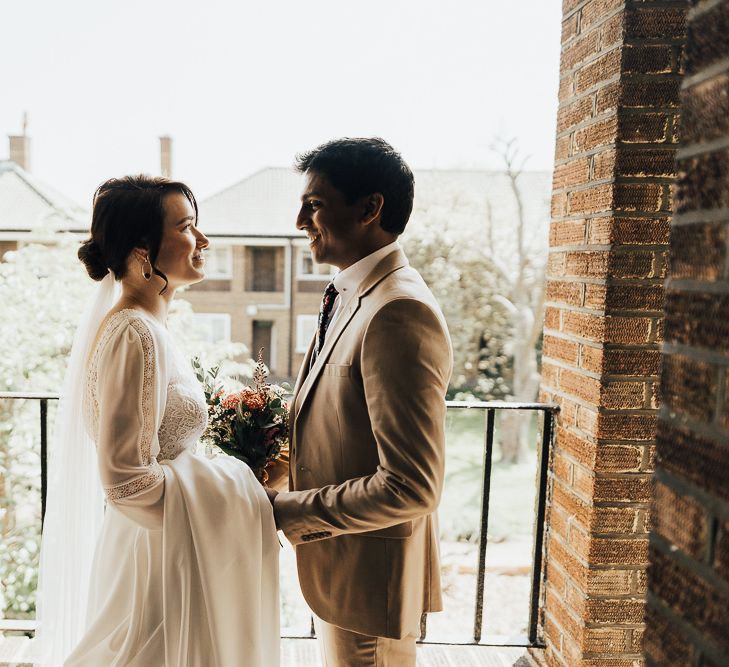 Bride in Rosa Clara wedding dress and Groom in beige suit on wedding morning