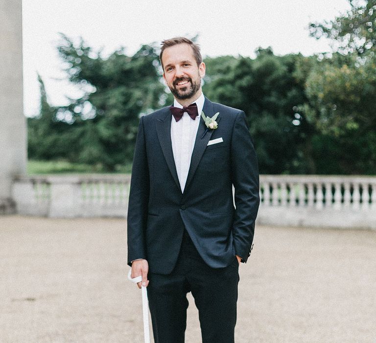 Groom in Navy Lanvin Tuxedo and Black Burberry Shoes | Burgundy Bow Tie | Paul the Pug | Stunning Syon Park Wedding with Quill Stationery Suite | Nancy Ebert Photography