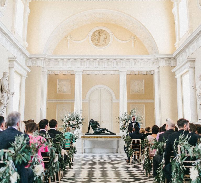 Wedding Ceremony at Syon Park | Groom in Navy Lanvin Tuxedo and Black Burberry Shoes | Burgundy Bow Tie | Huge Urns of Cafe au Lait Dahlias, David Austin Roses, Hydrangeas, Delphinium, Cosmos, Eucalyptus and Olive | Stunning Syon Park Wedding with Quill Stationery Suite | Nancy Ebert Photography